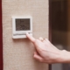 Woman switching a digital thermostat
